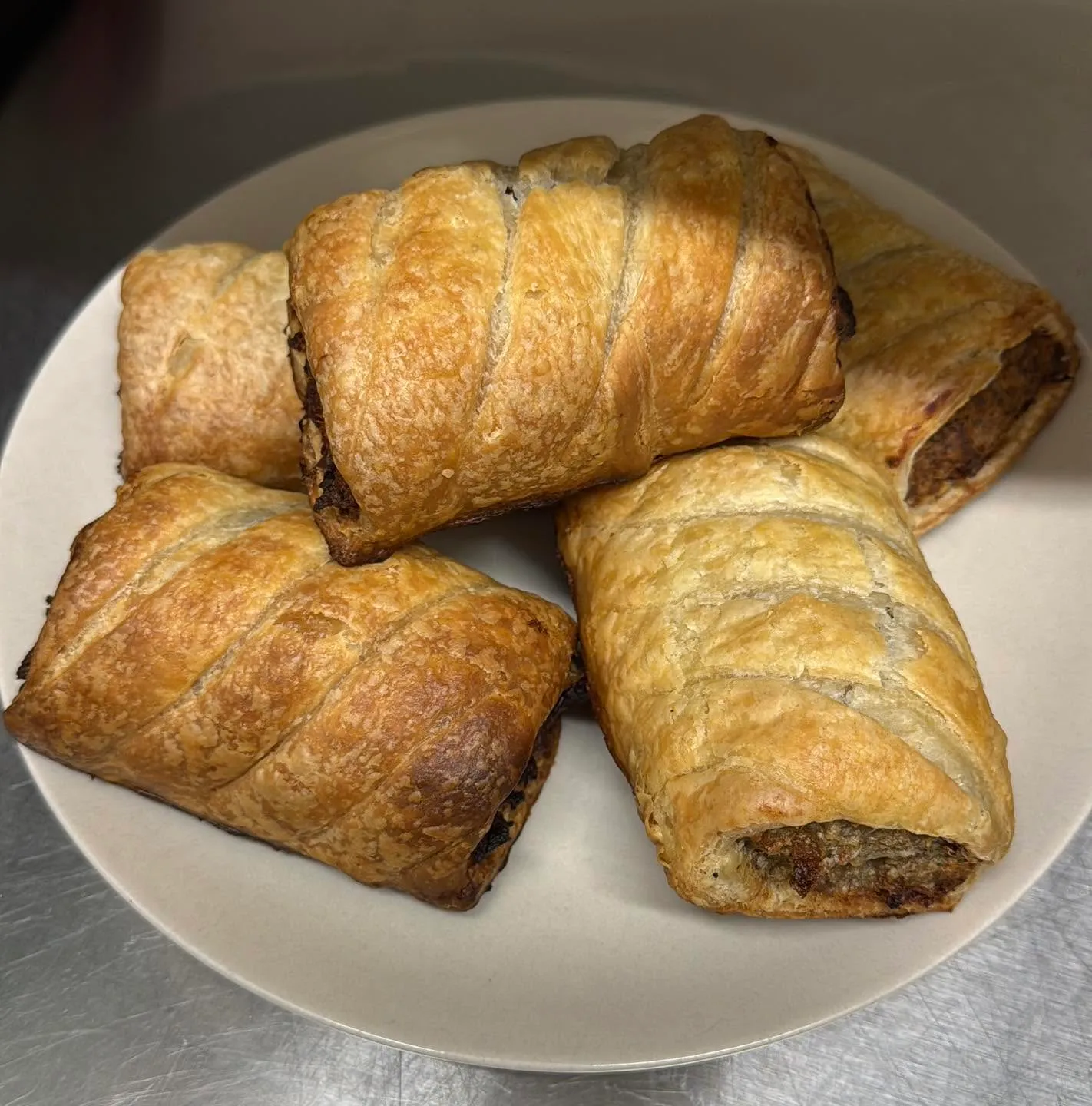 Plate of golden, flaky home-cooked sausage rolls